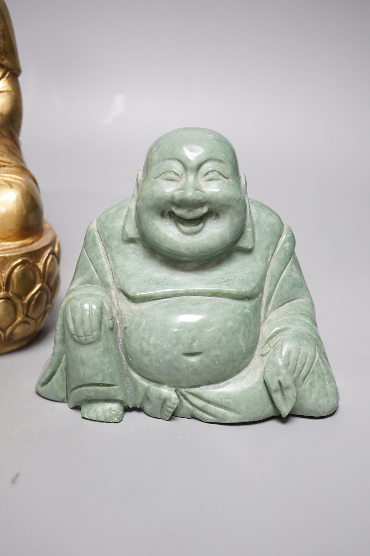 A Chinese greenstone Buddha, a soapstone carving of Shou Lao on carved hardwood stand, and a bronze figure of a seated Shaykamuni Buddha, tallest 29cm